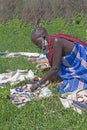 Elderly Massai woman selling handmade beaded jewelry on a blanket in Tanzania, Africa.